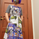 Quinn Dombrowski in a dress inspired by SUCHO they made. It features artwork commissioned for the project and a two-faced lion sculpture from the National Folk Decorative Art Museum.